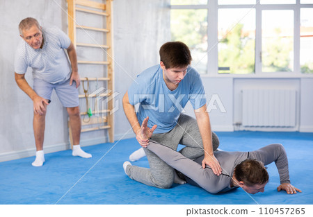 Guy practicing armlock in training bout during self-defence course Guy practicing armlock in training bout during self-defence course 110457265