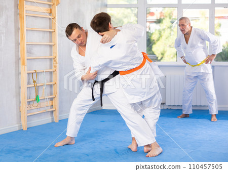 Adult and young men training judo fight 110457505