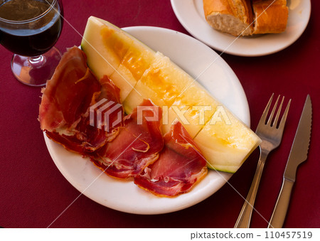 Mediterranian appetizers melon with ham on white plate. 110457519