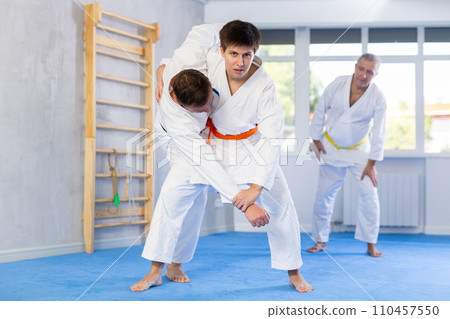 Young karate fighter honing fighting techniques during training kumite Young karate fighter honing fighting techniques during training kumite 110457550
