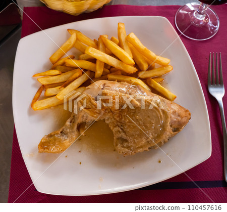 Stewed chicken leg quarter served with crispy fries 110457616