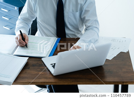 檢查分類帳的一位男性商人的手 檢查分類帳的一位男性商人的手 110457789