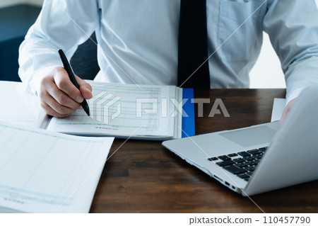 檢查分類帳的一位男性商人的手 檢查分類帳的一位男性商人的手 110457790