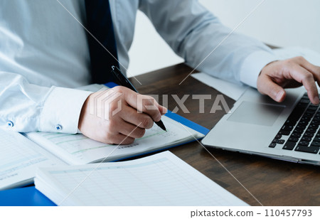檢查分類帳的一位男性商人的手 檢查分類帳的一位男性商人的手 110457793
