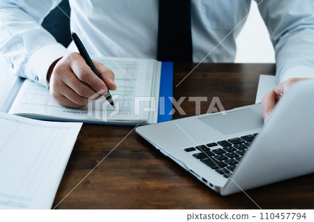 檢查分類帳的一位男性商人的手 檢查分類帳的一位男性商人的手 110457794