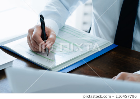 檢查分類帳的一位男性商人的手 檢查分類帳的一位男性商人的手 110457796