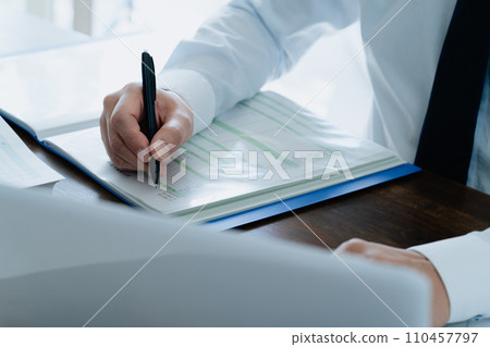 Hand of a male businessman checking the ledger Hand of a male businessman checking the ledger 110457797
