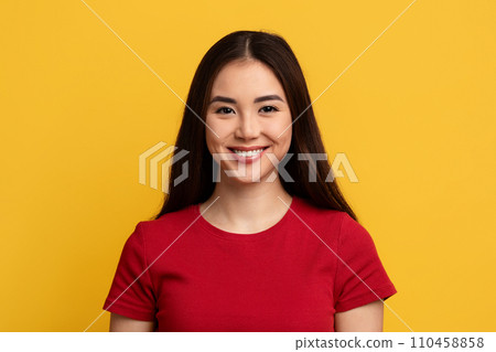 Portrait of attractive young asian woman posing on yellow background Portrait of attractive young asian woman posing on yellow background 110458858
