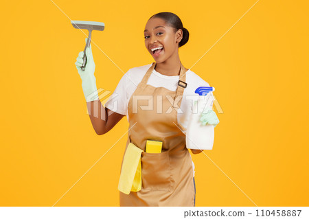 African cleaner lady holding detergent bottle and squeegee, studio shot 110458887