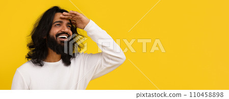 Curious indian man looking at copy space, yellow background Curious indian man looking at copy space, yellow background 110458898