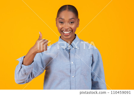 Happy black lady giving Thumbs Up gesture over yellow background Happy black lady giving Thumbs Up gesture over yellow background 110459091