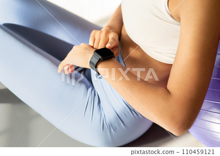 Close-up of a fitness-focused woman checking her smartwatch after a workout 110459121
