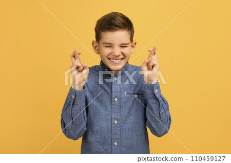 Cute Teen Boy Making Wish With Crossed Fingers And Closed Eyes 110459127