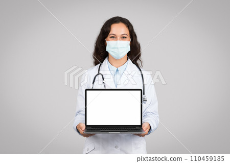 Doctor woman with mask presenting white laptop screen Doctor woman with mask presenting white laptop screen 110459185