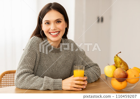 Portrait of smiling young brunette woman drinking fresh juice Portrait of smiling young brunette woman drinking fresh juice 110459207