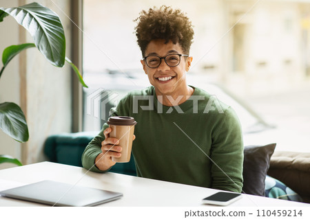 Stylish african american guy freelancer drinking coffee at cafe 110459214