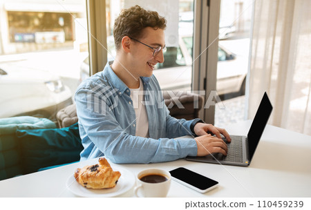 Positive busy millennial caucasian guy in glasses, typing on computer with empty screen Positive busy millennial caucasian guy in glasses, typing on computer with empty screen 110459239