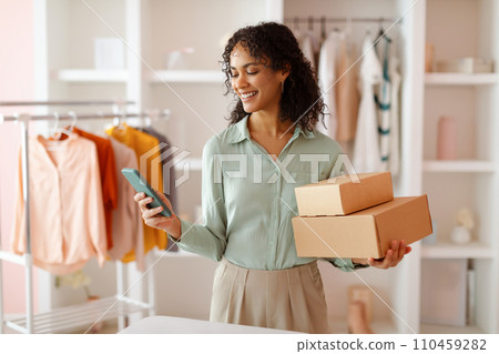 Entrepreneur with packages using smartphone in studio Entrepreneur with packages using smartphone in studio 110459282