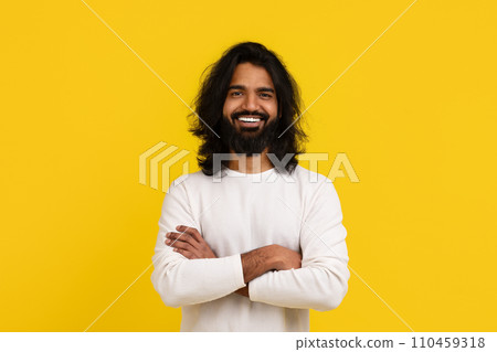 Stylish young indian guy posing isolated on yellow background 110459318