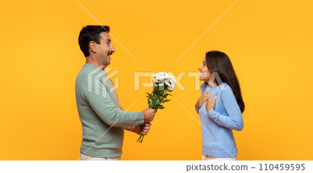 Smiling senior european husband give bouquet of flowers to surprised wife Smiling senior european husband give bouquet of flowers to surprised wife 110459595