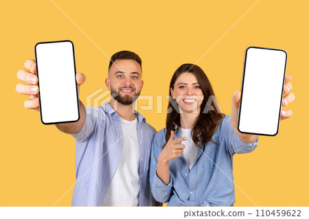 Cheerful couple holding smartphones with blank screens, ideal for mockups Cheerful couple holding smartphones with blank screens, ideal for mockups 110459622