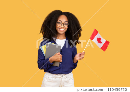 Smiling black lady student with Canadian flag and tablet on yellow Smiling black lady student with Canadian flag and tablet on yellow 110459750