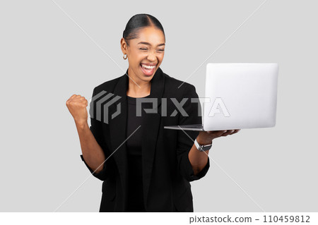 Exuberant African American woman in professional attire celebrating success with a fist pump Exuberant African American woman in professional attire celebrating success with a fist pump 110459812