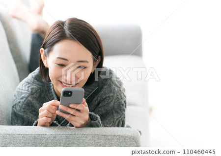 A woman in her 30s relaxing in the living room A woman in her 30s relaxing in the living room 110460445
