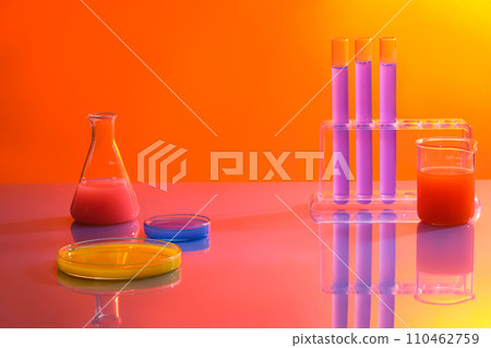 Minimal background with lab concept. Test tubes, beaker, erlenmeyer flask and petri dishes filled with colorful solution on orange gradient background. Space for cosmetics and product presentation 110462759