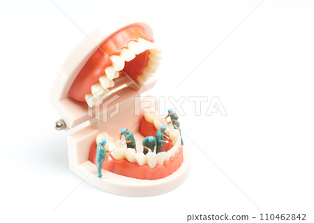 Miniature people , Dentist repairing human teeth with gums and enamel 110462842