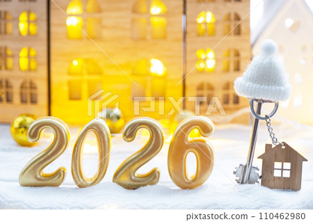 Golden figures number 2026, key and tiny home on background of cozy windows of a house with warm light with festive decor of stars,snow and garlands. Greeting card, Happy New Year, cozy home Golden figures number 2026, key and tiny home on background of cozy windows of a house with warm light with festive decor of stars,snow and garlands. Greeting card, Happy New Year, cozy home 110462980