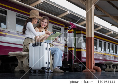 Travel concept. girl friend wear hat holding map have bag and luggage. female traveller waiting train at train station 110463433