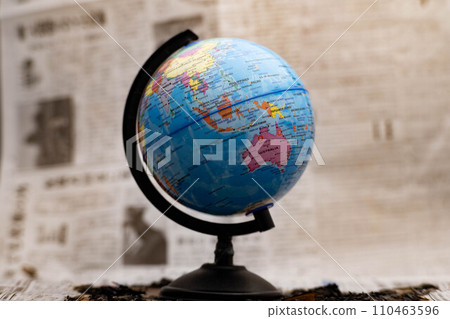Model globe on a newspaper in the background. Model globe on a newspaper in the background. 110463596