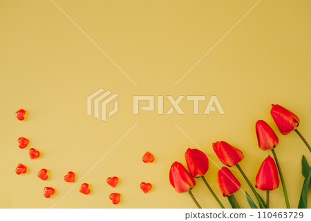 Bouquet of tulips and red hearts on a yellow background with copying space Festive greeting card for Valentine's Day Bouquet of tulips and red hearts on a yellow background with copying space Festive greeting card for Valentine's Day 110463729