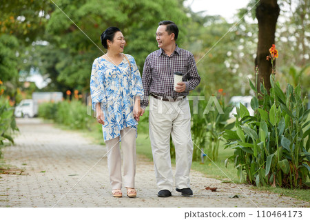 Cheerful Vietnamese couple in love walking in park 110464173