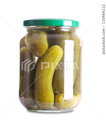 Whole gherkins, pickled cucumbers, in a glass jar. Crunchy pickles, pasteurized and preserved in a brine of vinegar, salt, mustard seeds and dill. Close-up, front view on white background. Food photo. 110464222
