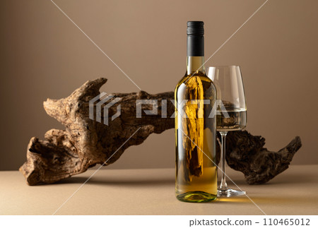 White wine and old snag on a beige background. White wine and old snag on a beige background. 110465012