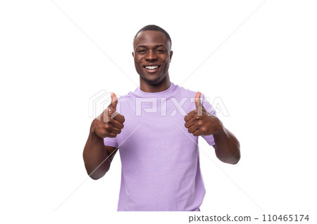 young positive american man in a lilac t-shirt is inspired by an idea and success on a white 110465174