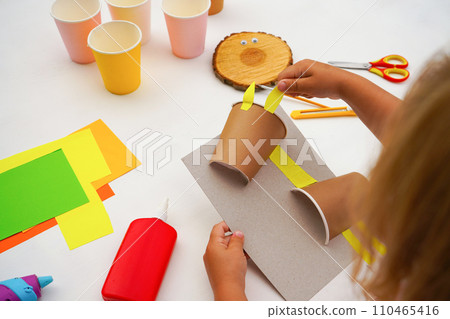 Step by step diy process. Point 4 glue the legs, ears and tail cut out of paper. Kids craft giraffe from a paper coffee cup, zero waste concept. Step by step diy process. Point 4 glue the legs, ears and tail cut out of paper. Kids craft giraffe from a paper coffee cup, zero waste concept. 110465416