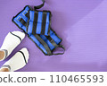Female feet in white socks stand on a yoga mat where fabric weights for the feet lie. 110465593