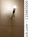 An energy-saving light bulb in a socket with a black wire on a beige wall. The concept of caring for nature. 110465600