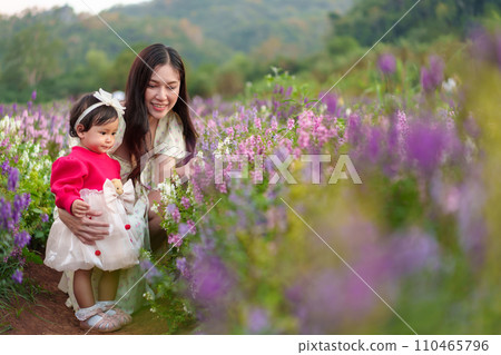 mother and her daughter enjoying Angelonia flower blooming mother and her daughter enjoying Angelonia flower blooming 110465796
