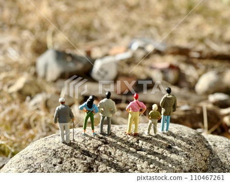 Six figures standing on a rock overlooking the rubble 110467261
