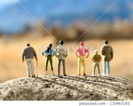 Rear view of six dolls standing on rocks and looking at nature Rear view of six dolls standing on rocks and looking at nature 110467265