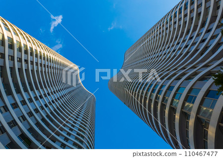 Curvilinear modern skyscrapers soar against a clear blue sky 110467477