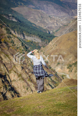 The girl admires the expanse of the mountains The girl admires the expanse of the mountains 110467658