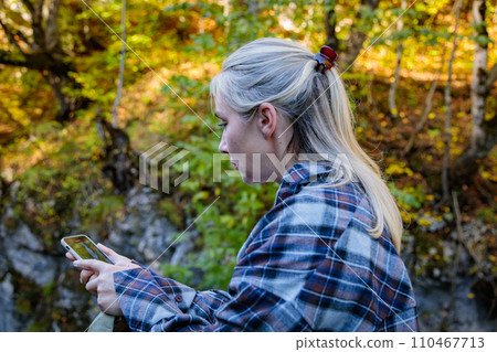Girl taking pictures of a mountain gorge Girl taking pictures of a mountain gorge 110467713