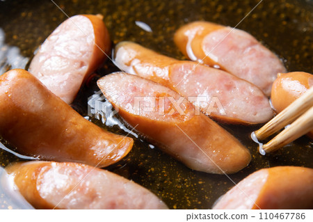 A cooking scene where sausages are simmered in soup stock to make eggs. 110467786