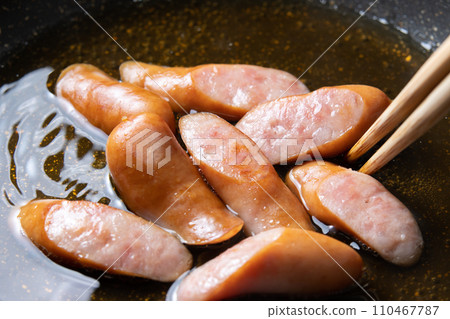 A cooking scene where sausages are simmered in soup stock to make eggs. 110467787