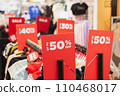 Red discount signs on clothes racks in a clothing store 110468017